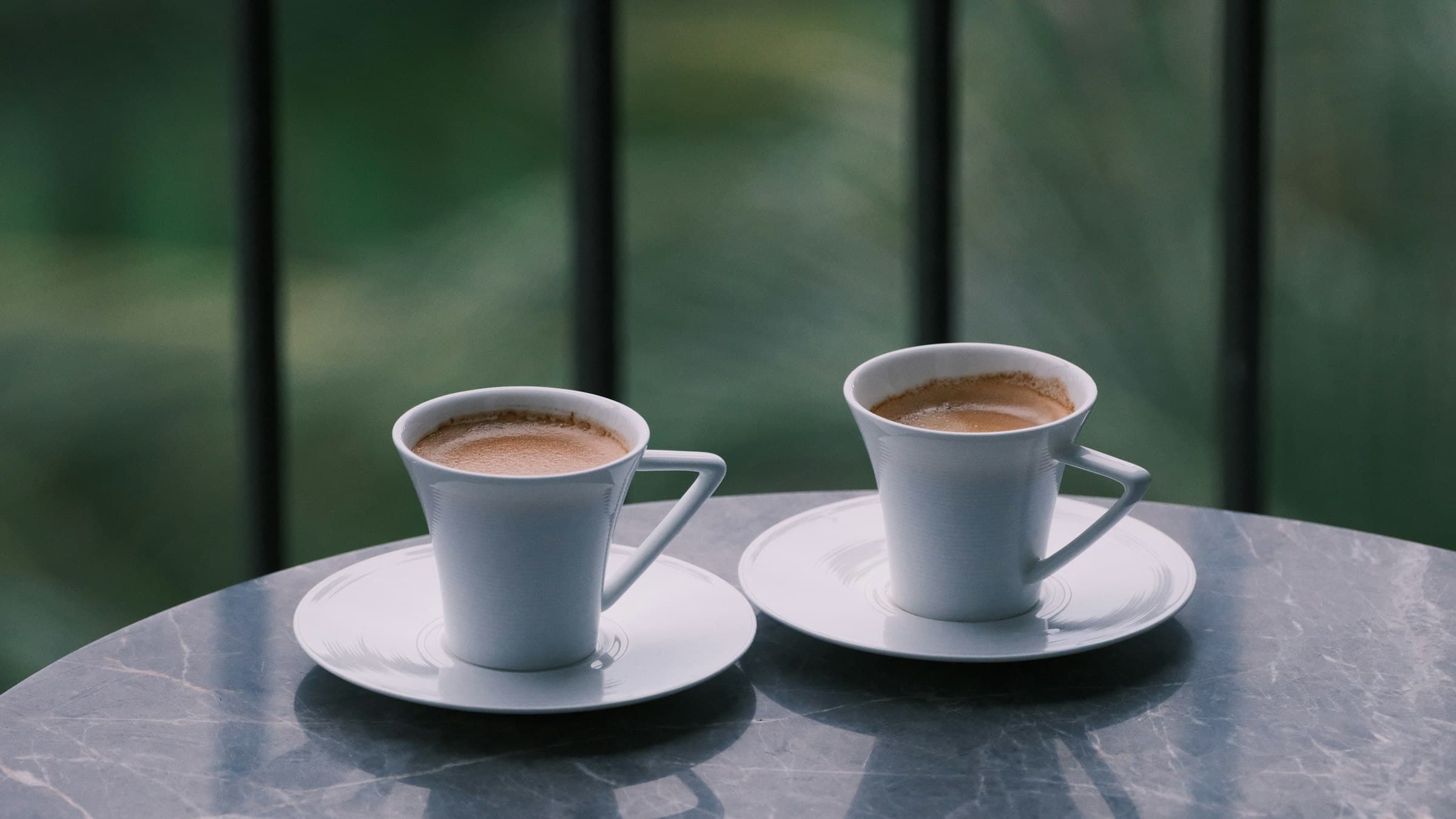 Twee kopjes koffie op een marmeren tafeltje