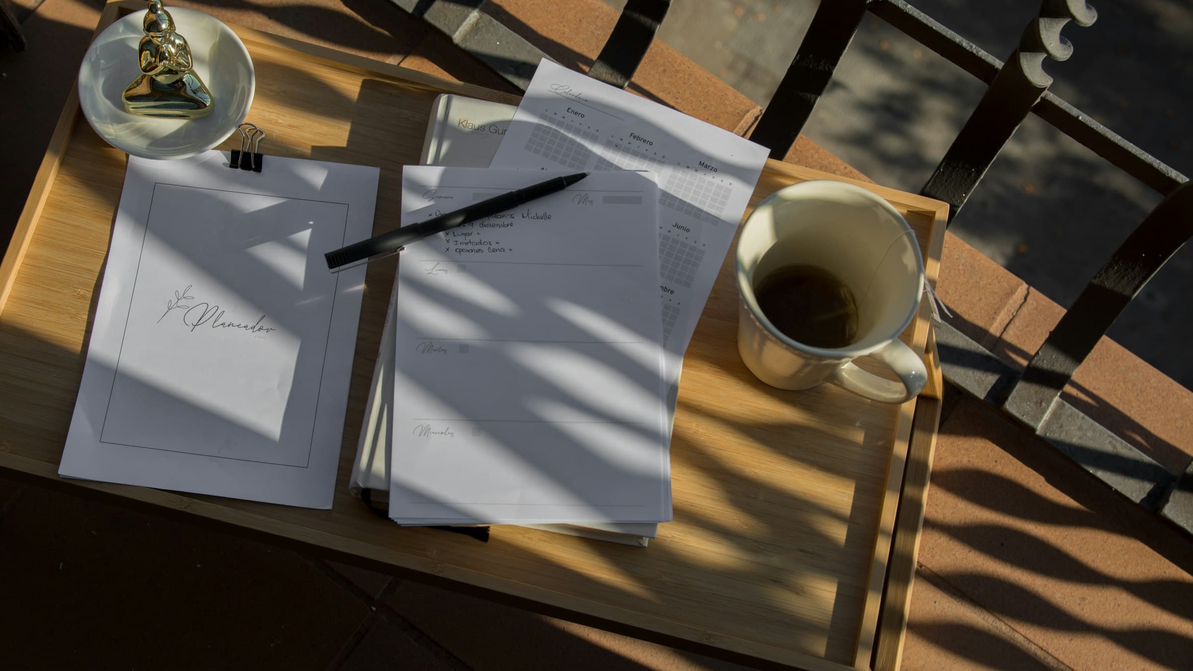 Papers with a pen and a cup of coffee in the sunlight