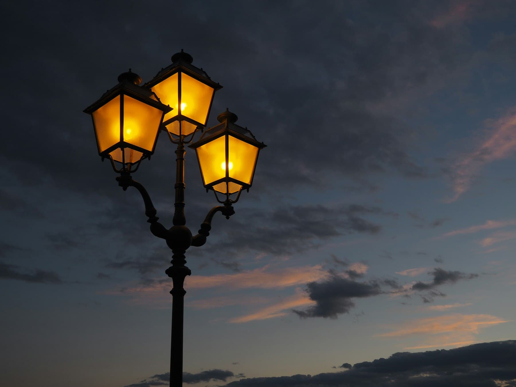Verlichte straatlantaarns tegen een avondlucht als symbool van veiligheid