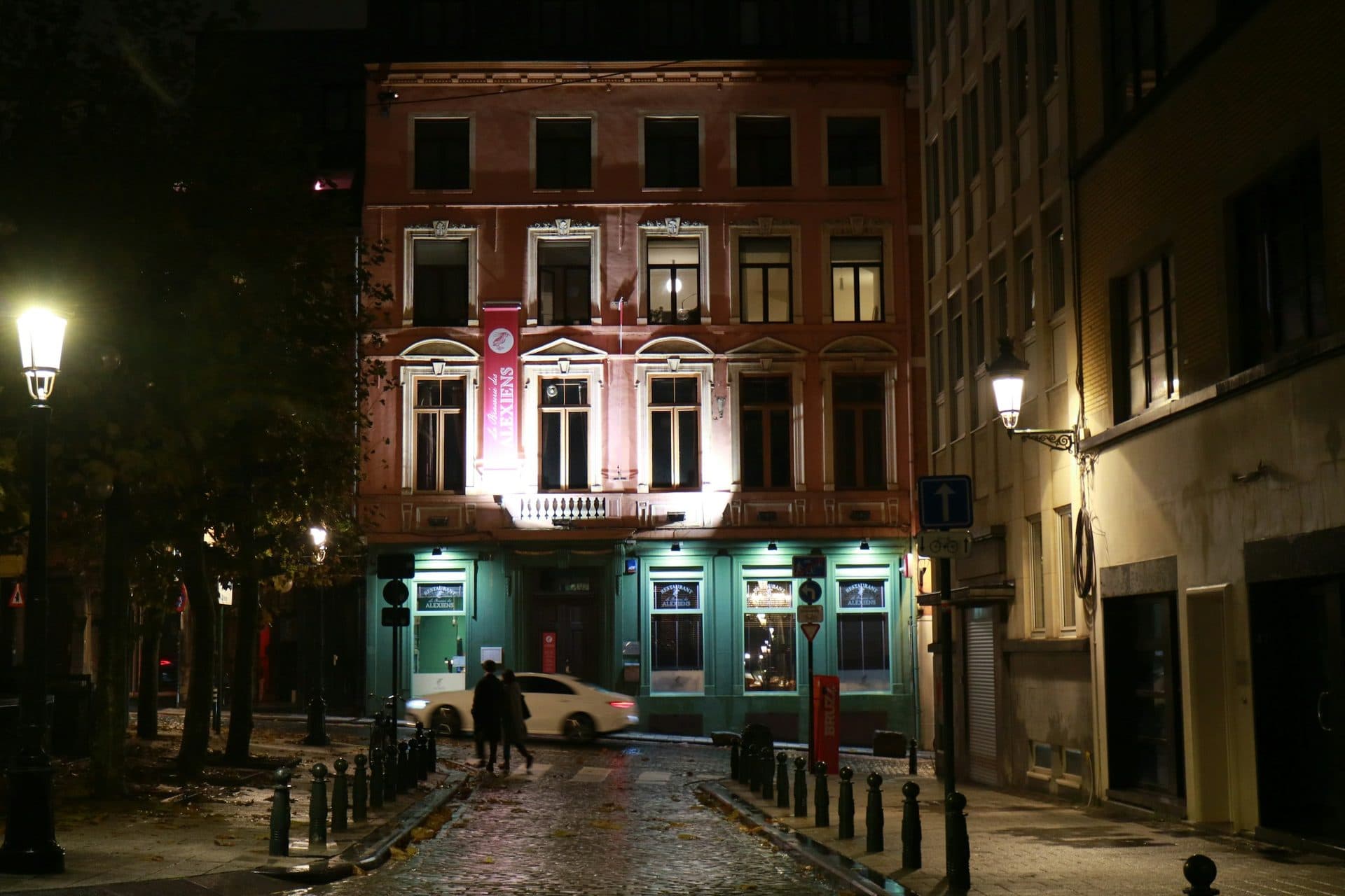 Verlichte gevels en lantaarns in een straat in Brussel bij avond